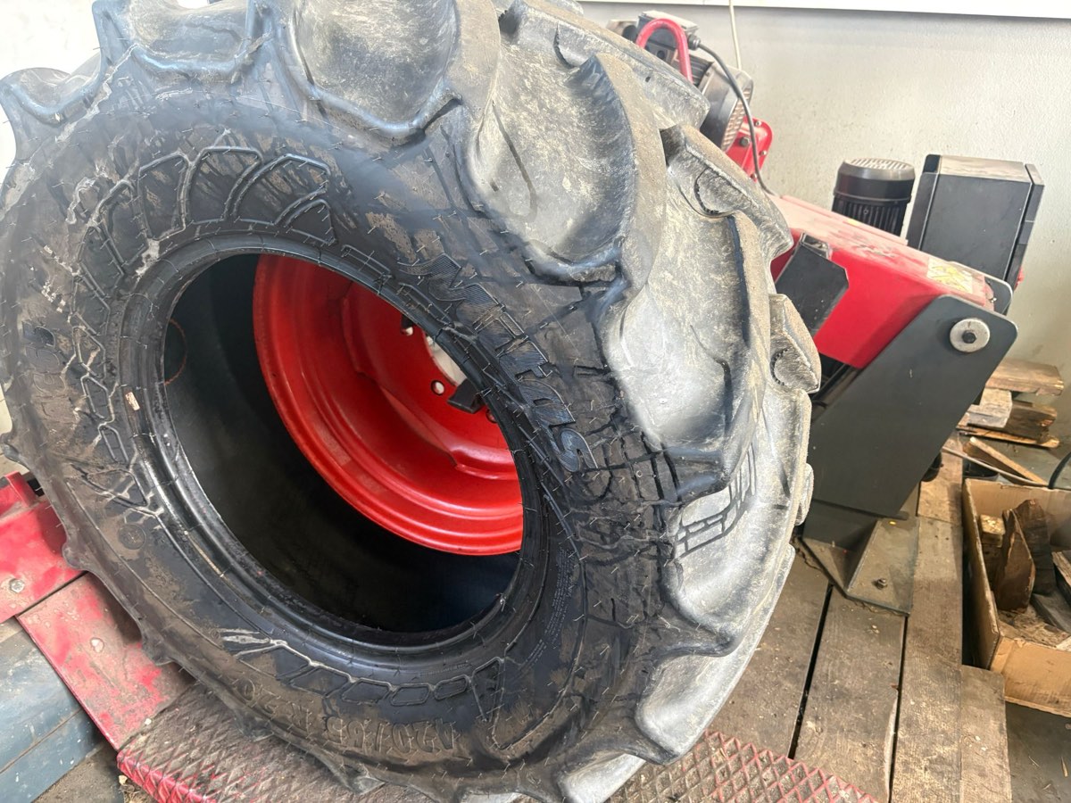 Traktorreifen auf roter Felge an der Reifenmontiermaschine in unserer Werkstatt