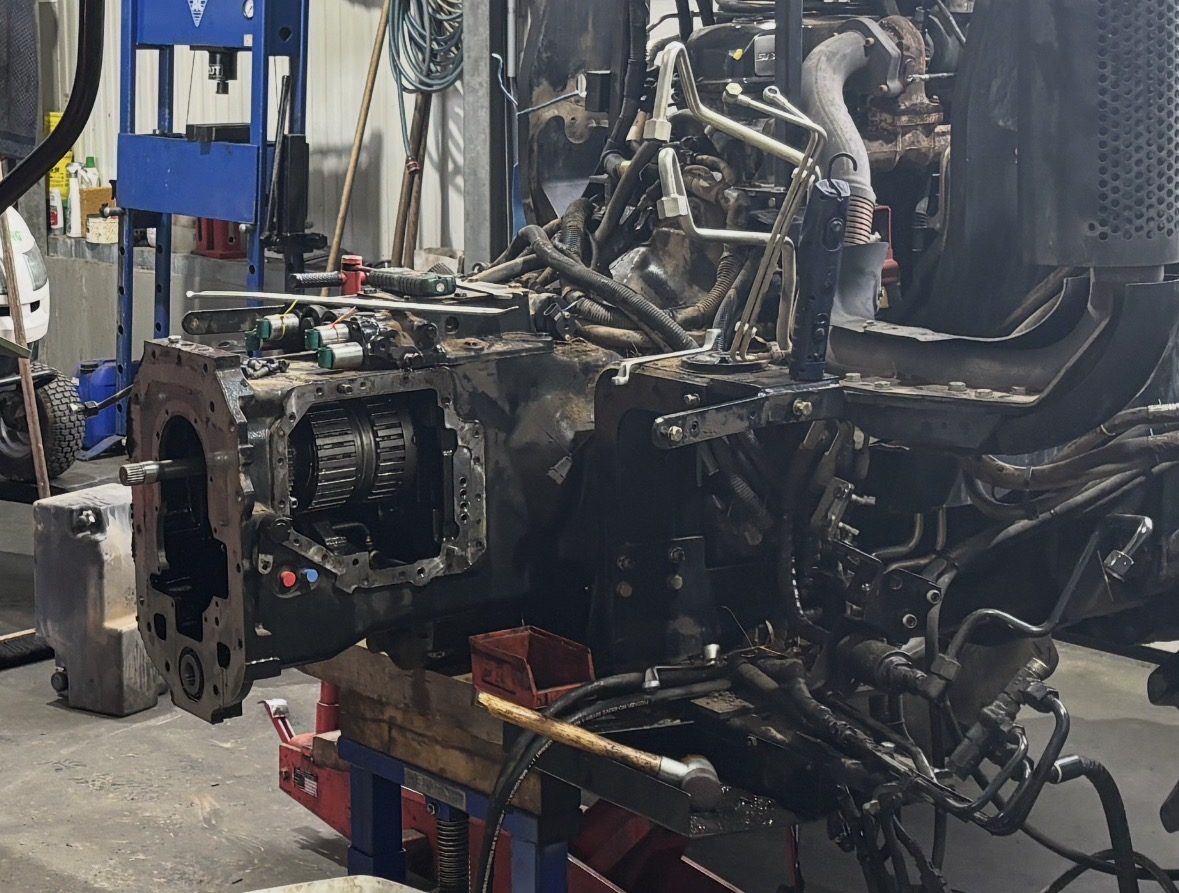 Traktor in unserer Werkstatt, zwischen Motor und Getriebe getrennt für eine Reparatur am Getriebe